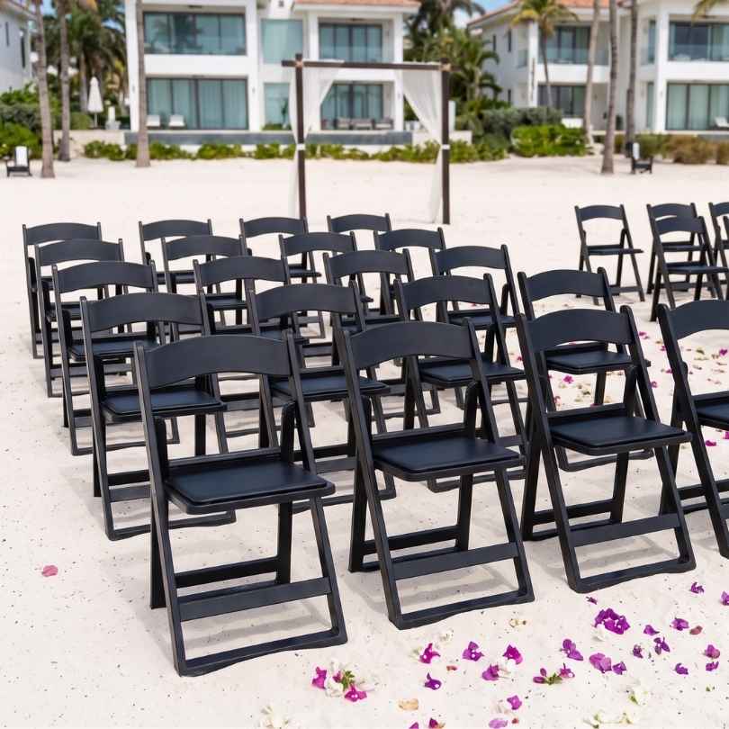 Rows of black Grass and Sand chairs set on sand