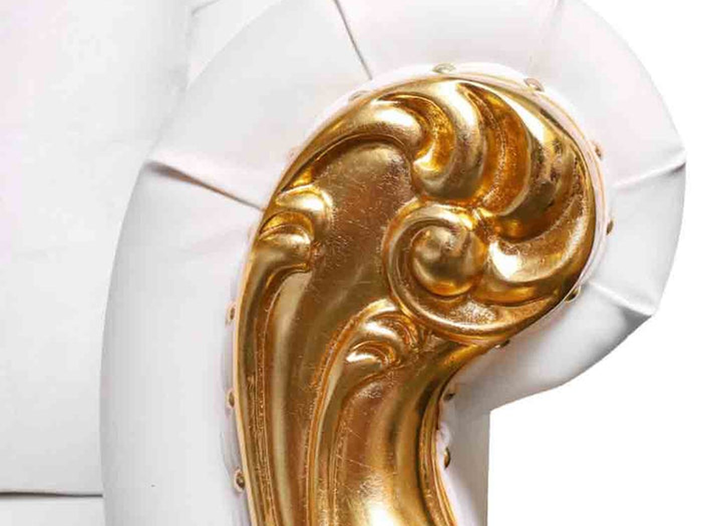 Gold-leafed scrollwork against button-tufted white vinyl. Vinyl wipes clean, which matters more at a wedding than anyone admits.