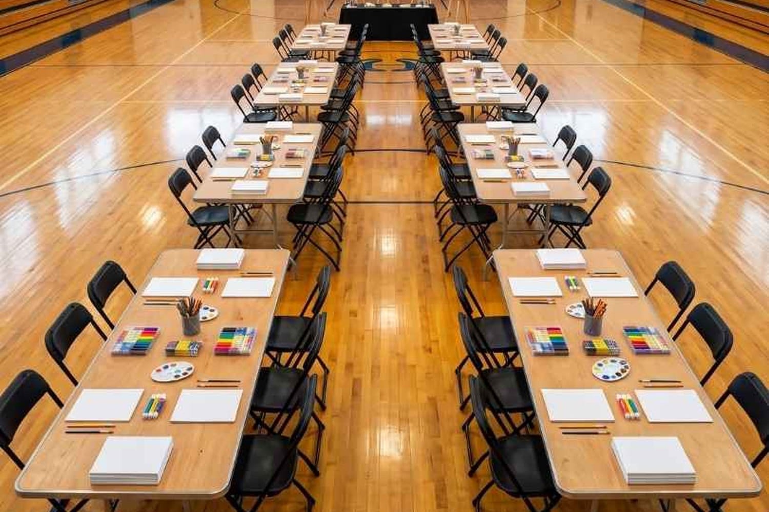 **[Samson-Series Steel-Poly](https://chivari.com/products/samson-series-black-plastic-folding-chair)** in a multi-purpose hall. 7.5 lbs and a 15.5-inch square footprint — the reason a volunteer team can flip a room this size in one pass.