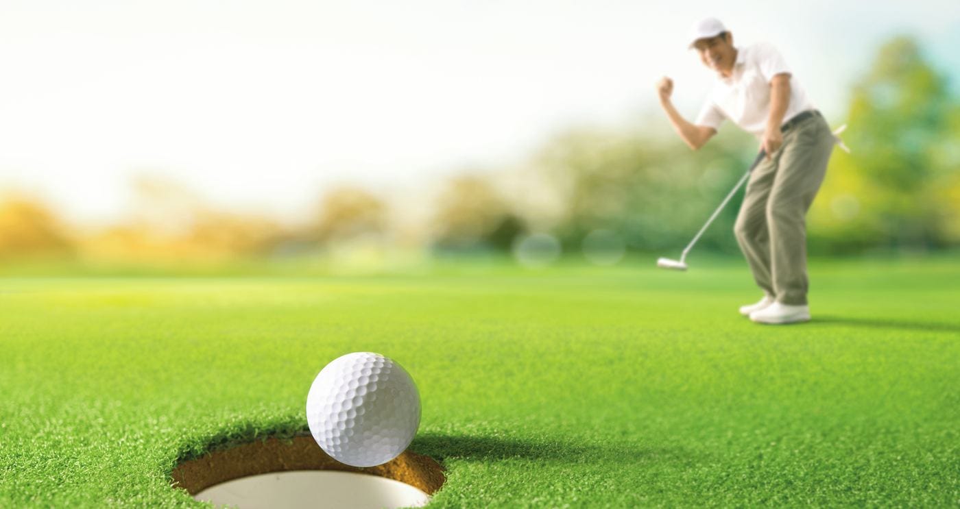 Golfer celebrating a putt dropping into the cup